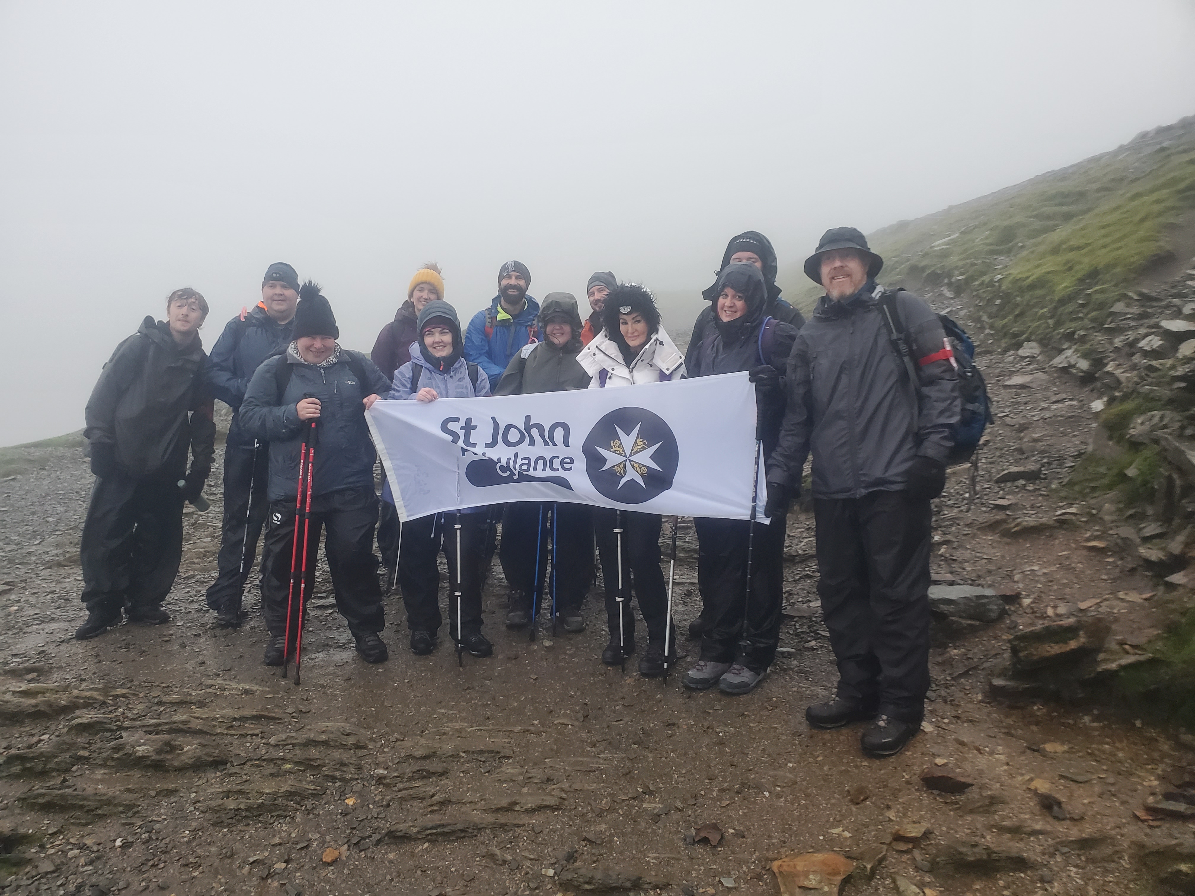 a group of people at the top of pen y fan on a charity hike